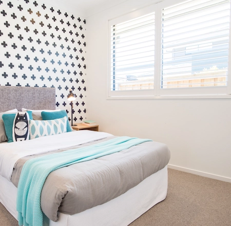 White plantation shutters in a guest bedroom with natural light
