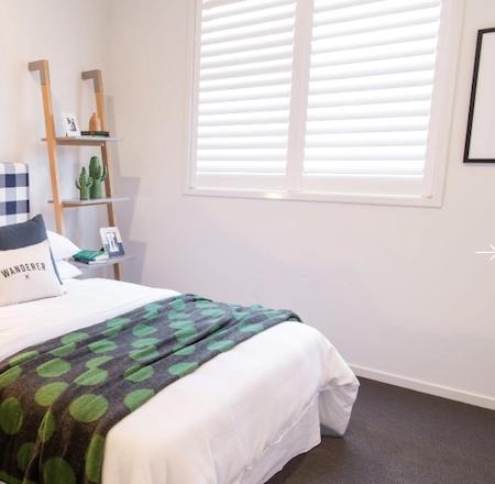 White plantation shutters in a bedroom for privacy and light control