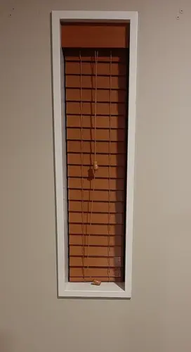 Narrow made-to-measure wooden venetian blind installed inside a small window recess