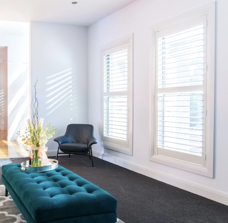White plantation shutters controlling natural light in a bright living space